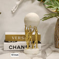 golden human figures holding a sphere/globe table accent sculpture