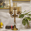 3-arm gold candelabra with glass hurricane shades