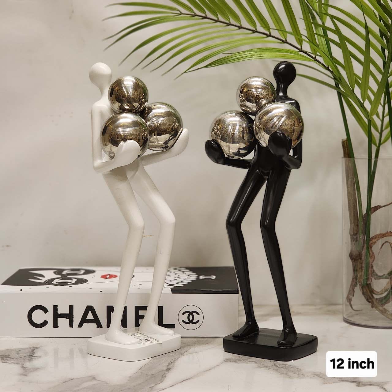 Minimalist Humanoid Figurine Holding Chrome Orbs